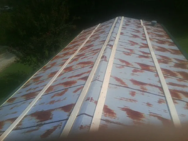 Rusted metal roof panels with new wood purlins before replacement — Storm Damage Roof Repair in Arispe by Roofing Brothers