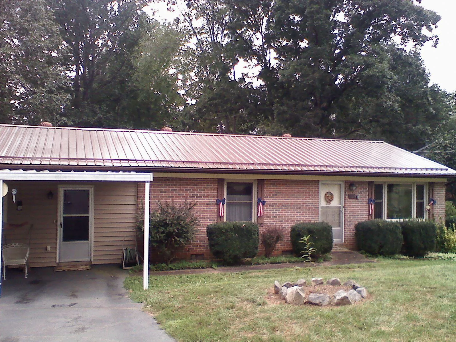 Bronze metal roof and carport on a brick ranch home — Roof Repair work by our crew in Arispe